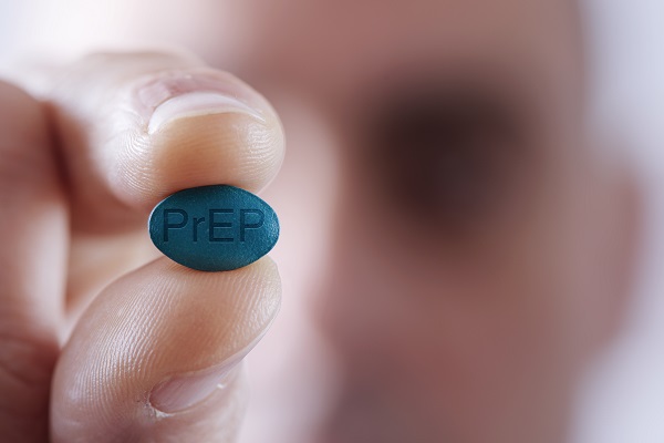 Man holding HIV PrEP pill up to camera