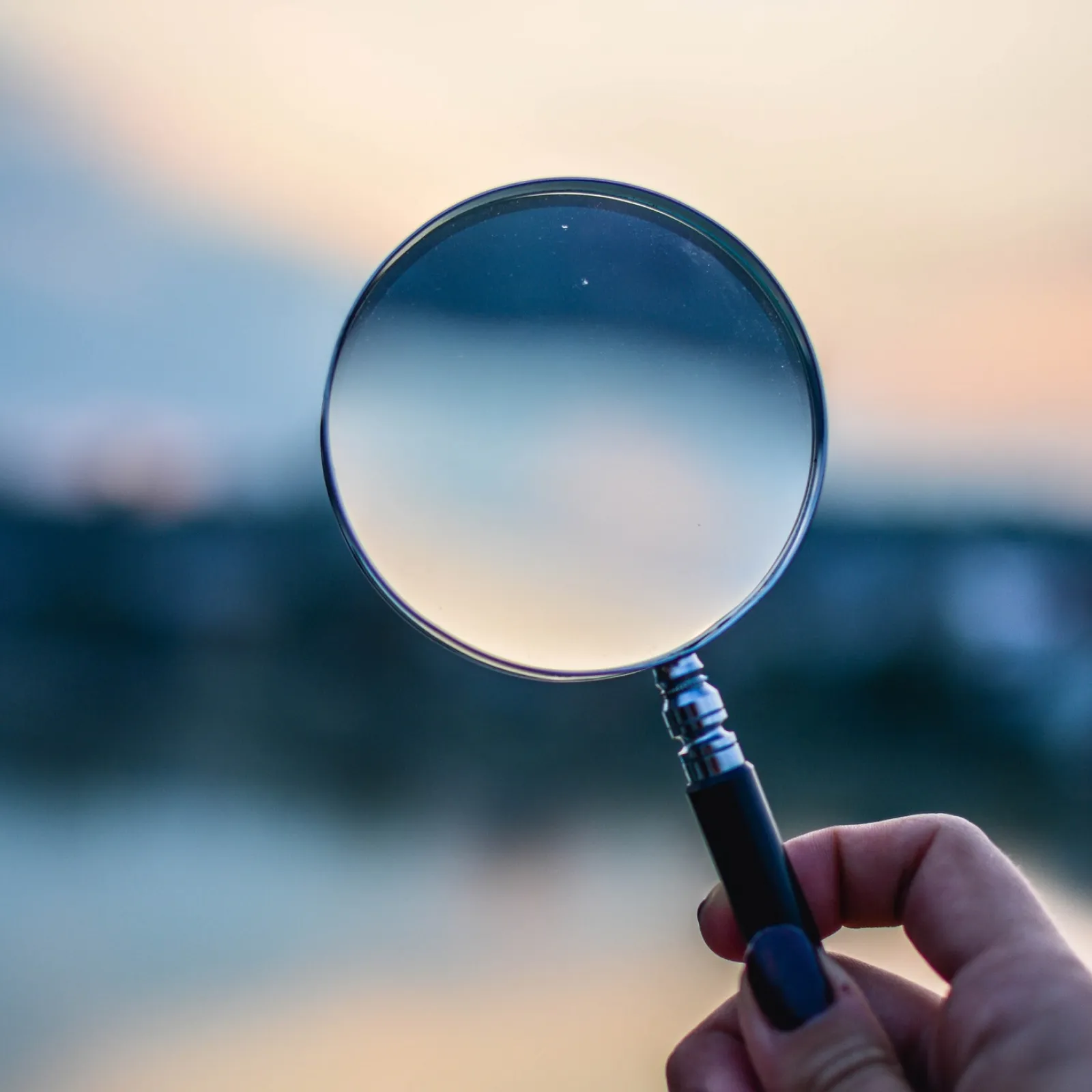 Hand holding magnifying glass