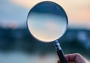 Hand holding magnifying glass