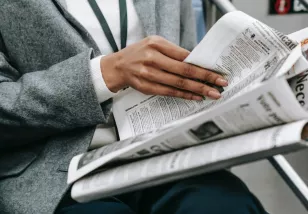 woman on train reading newspaper