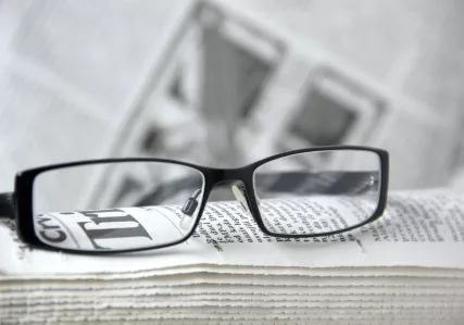 eyeglasses resting on a newspaper