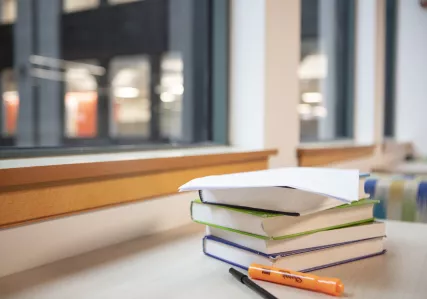 Books, highlighter, and pen on a table overlooking the atrium