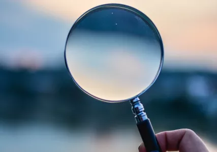 Hand holding magnifying glass